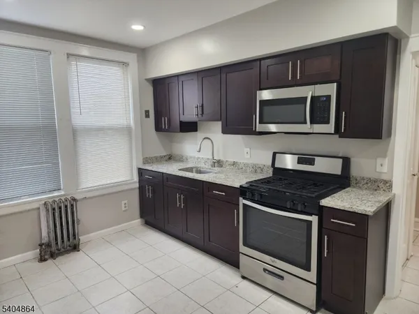 a kitchen with stainless steel appliances granite countertop a stove microwave and sink