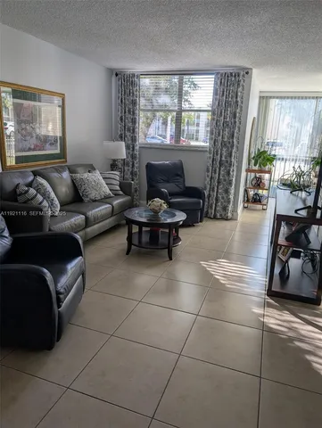 a living room with furniture a flat screen tv and a large window