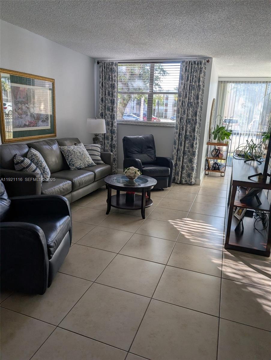 a living room with furniture a flat screen tv and a large window