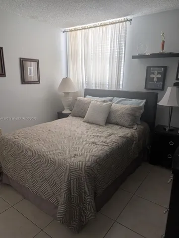 a large bed sitting in a bedroom next to a window