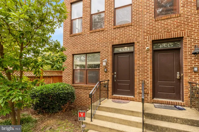 a front view of a house with a tree