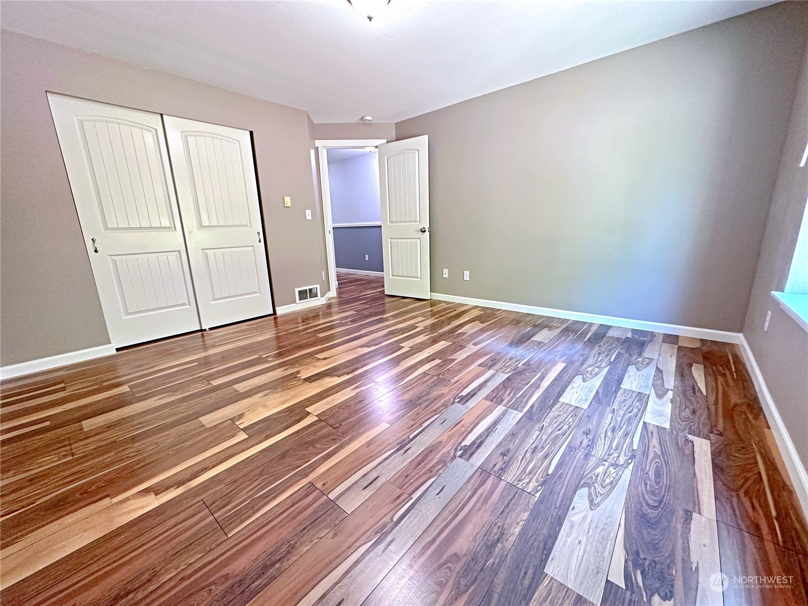 8307 Waddell Creek Road Southwest Olympia, WA 98512 - Photo 15 of 33 a view of an empty room with wooden floor and a window