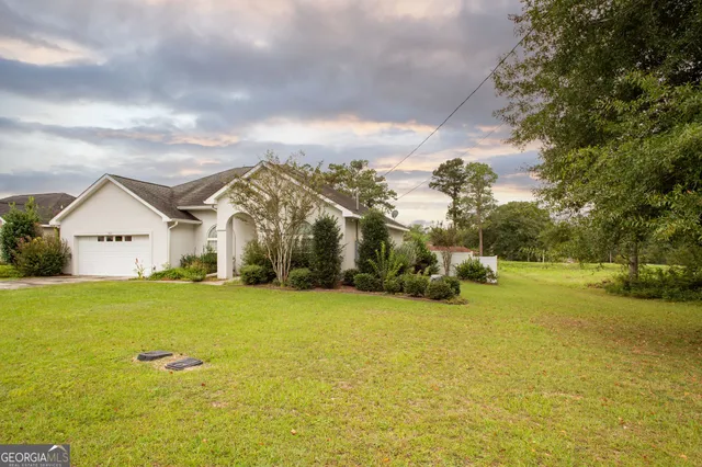 a view of a house with yard and lake view