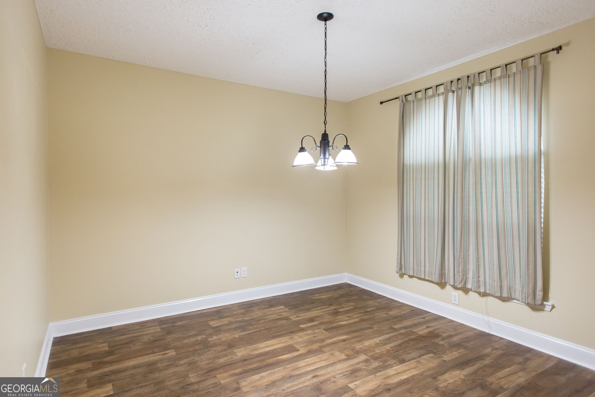 2869 Ben Street Waycross, GA 31503 - Photo 6 of 37 a view of empty room with wooden floor fan and window