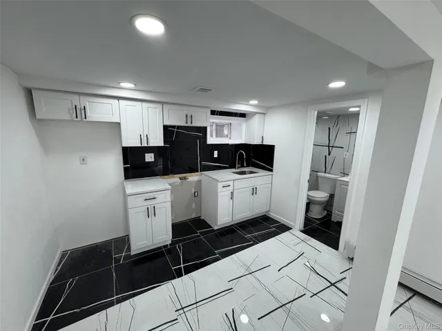 a kitchen with a sink a refrigerator and cabinets