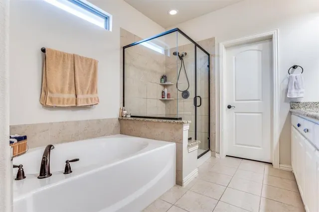 a bathroom with a tub a sink and a shower