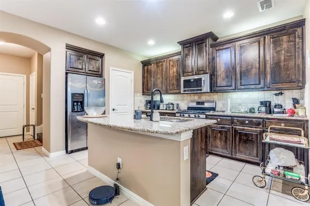 a kitchen with stainless steel appliances granite countertop a sink stove and cabinets
