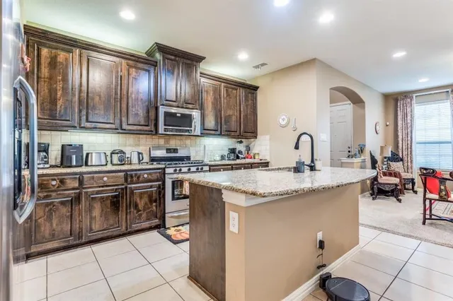 a kitchen with stainless steel appliances granite countertop a sink stove and cabinets