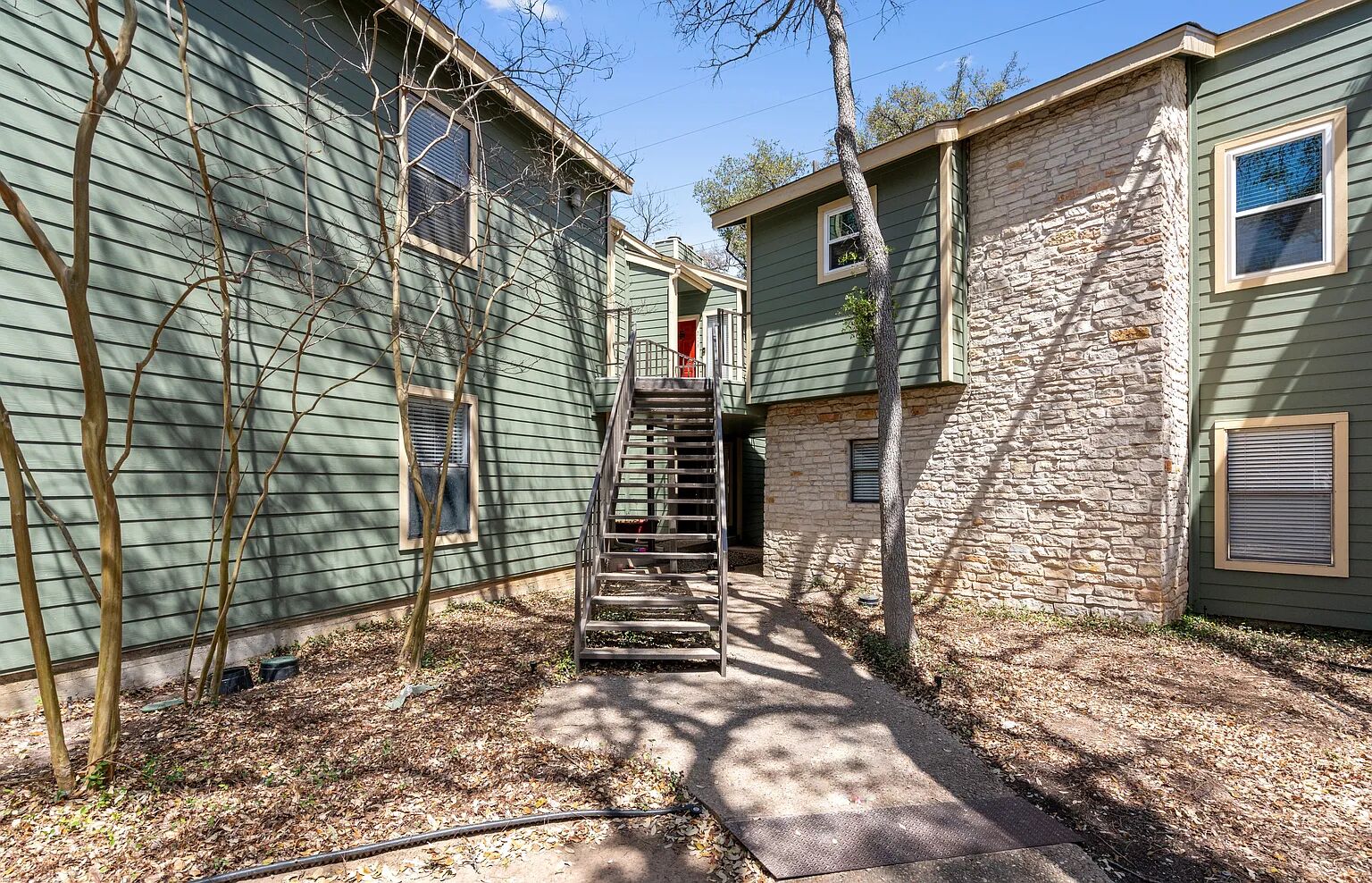11970 Jollyville Road, Unit 202 Austin, TX 78759 - Photo 22 of 25 A striking exterior combines green siding with natural stone accents, creating visual interest and character.