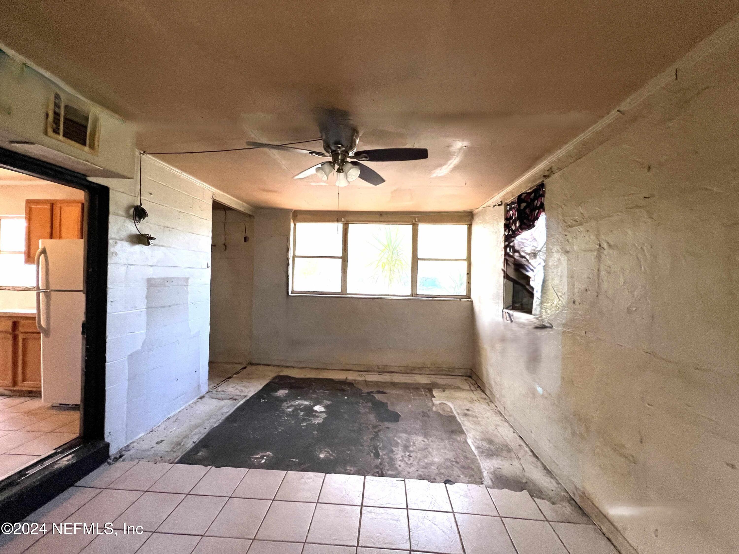 1857 Brookview Drive South Jacksonville, FL 32246 - Photo 7 of 12 a view of an empty room and window chandelier fan and kitchen view