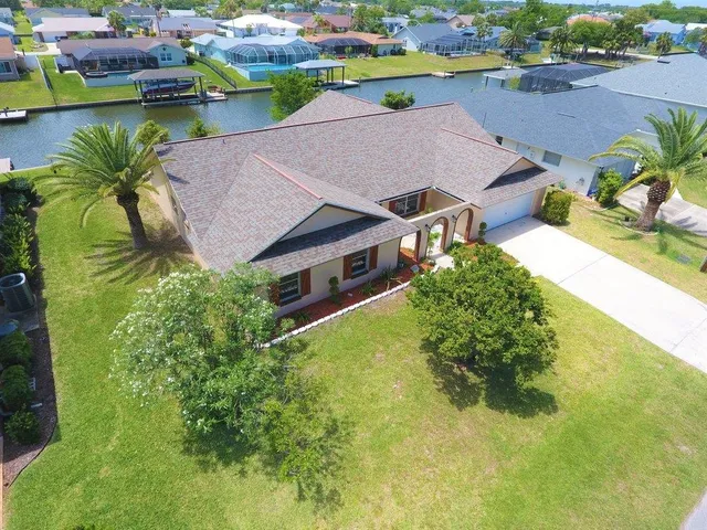 an aerial view of a house with swimming pool and ocean view