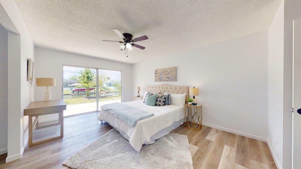 10 Coral Reef Court Palm Coast, FL 32137 - Photo 13 of 44 a bedroom with a large bed and a chandelier