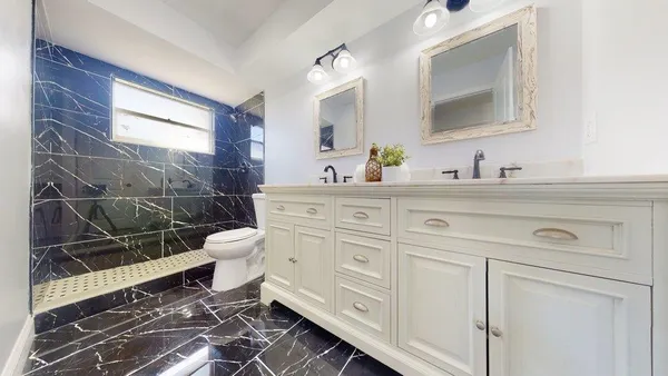 a spacious bathroom with a toilet sink and mirror