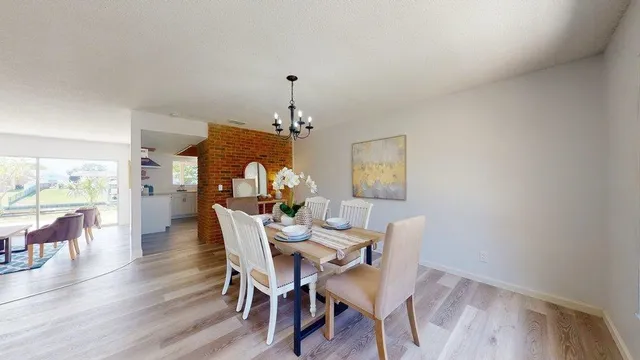 a view of a hallway with wooden floor and dining room