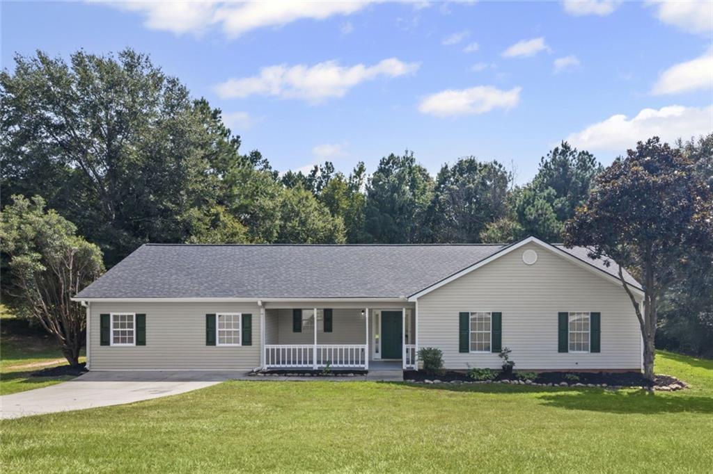 a front view of house with yard and trees in the background