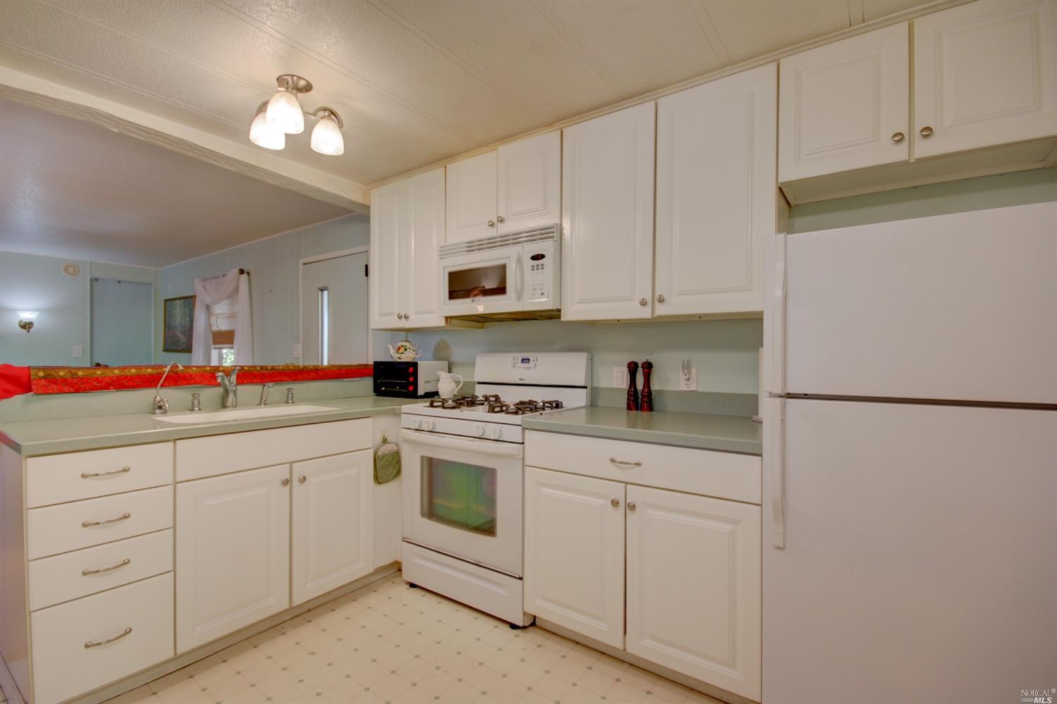 53 Yosemite Road, Unit 53 San Rafael, CA 94903 - Photo 1 of 1 a kitchen with white cabinets and white appliances