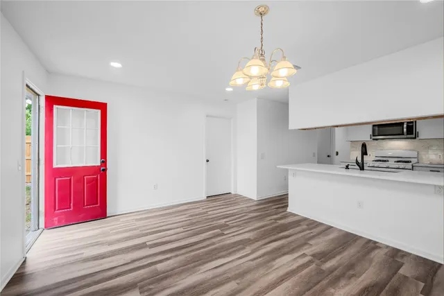 a view of kitchen with granite countertop stainless steel appliances stove and kitchen island
