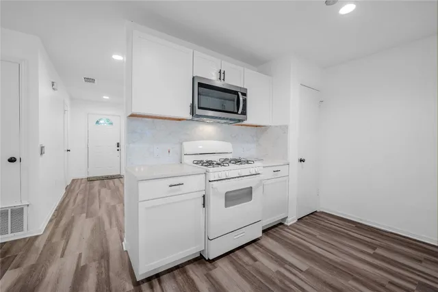 a kitchen with stainless steel appliances white cabinets and a sink