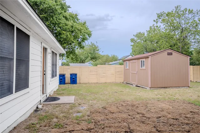 a view of a house with a yard and large tree