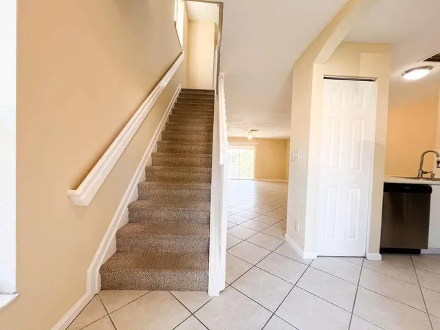 a view of a hallway with wooden floor and a bathroom