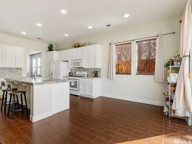 a kitchen with a refrigerator and white cabinets