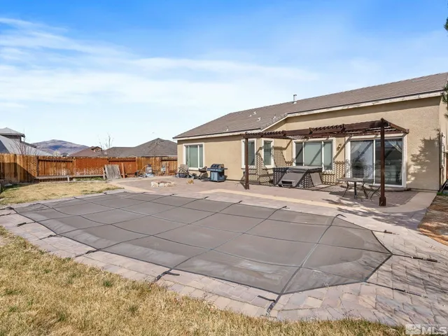 a view of a swimming pool with a patio and a backyard