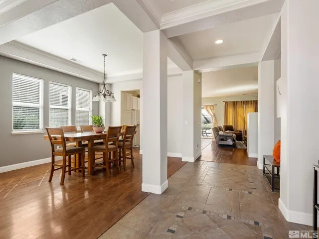 a view of a dining room and livingroom with furniture wooden floor a chandelier