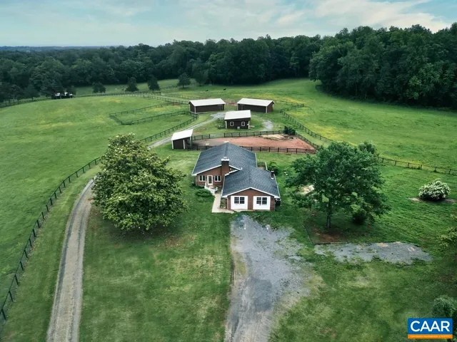 a kitchen with stainless steel appliances granite countertop a refrigerator a sink dishwasher a stove and a dining table with wooden floor