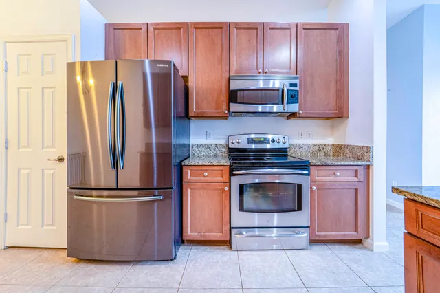 a kitchen with stainless steel appliances granite countertop a refrigerator stove and microwave