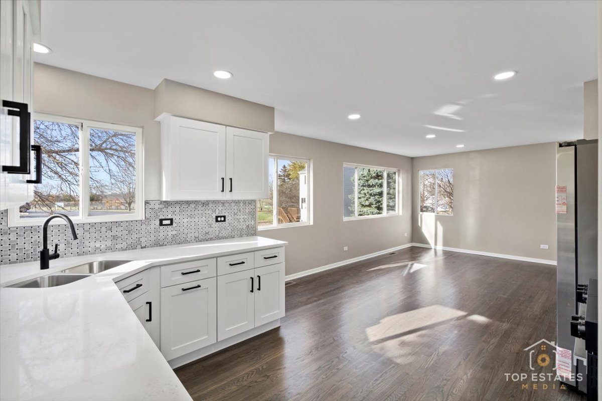 737 Springwood Drive Joliet, IL 60431 - Photo 6 of 31 a large kitchen with stainless steel appliances granite countertop a sink cabinets and wooden floor