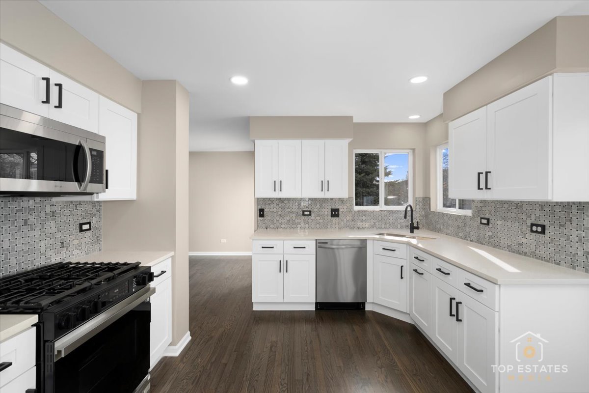 737 Springwood Drive Joliet, IL 60431 - Photo 7 of 31 a kitchen with granite countertop white cabinets and stainless steel appliances