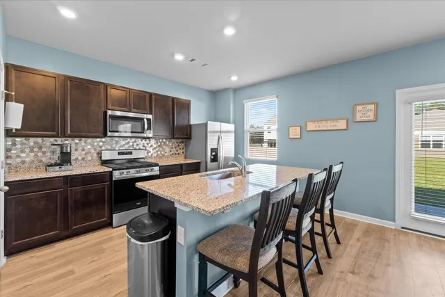 a kitchen with a dining table chairs and refrigerator