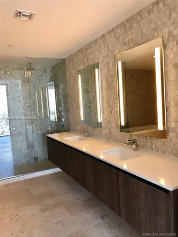 a bathroom with a double vanity sink and a mirror