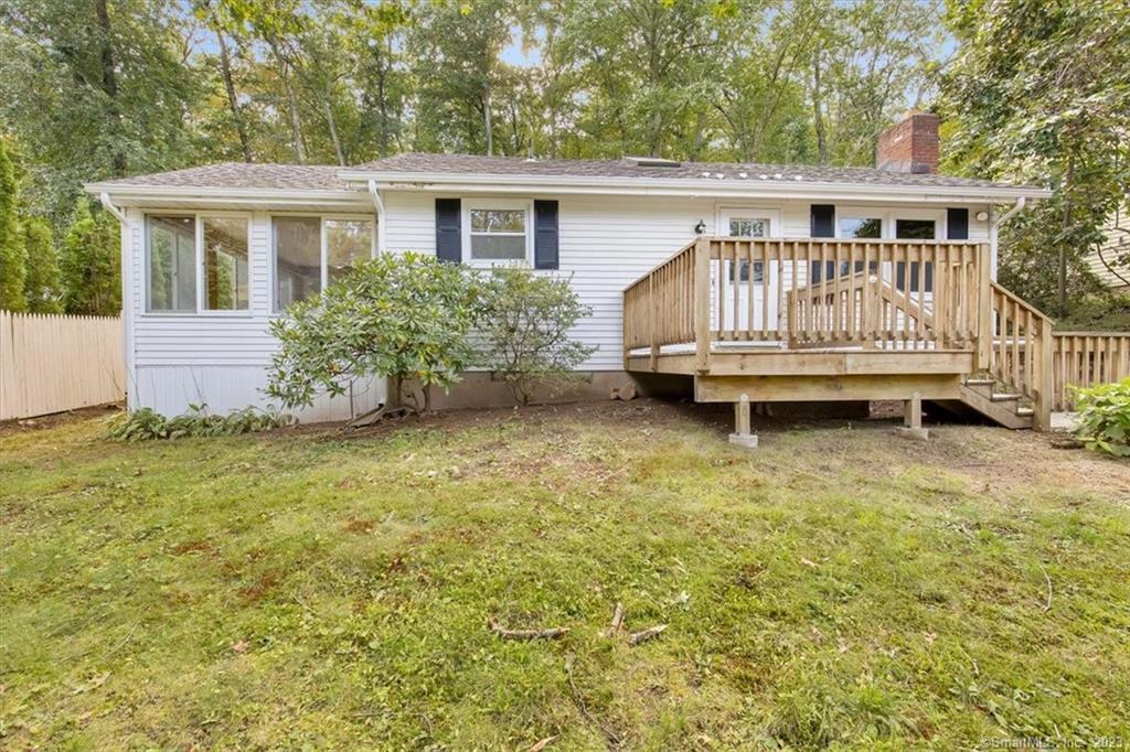 a view of a house with a yard and deck area