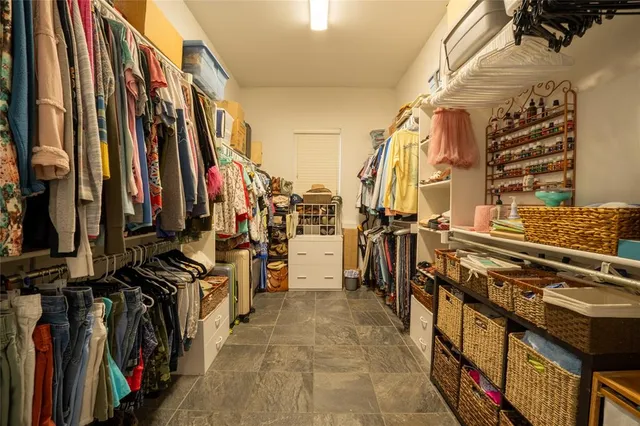 a view of walk in closet with clothes and shoes
