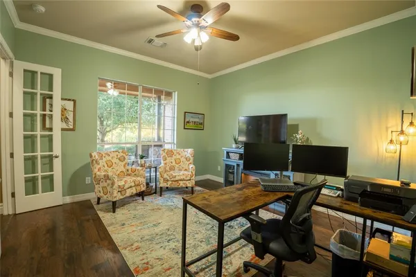 a view of a workspace with furniture and a window