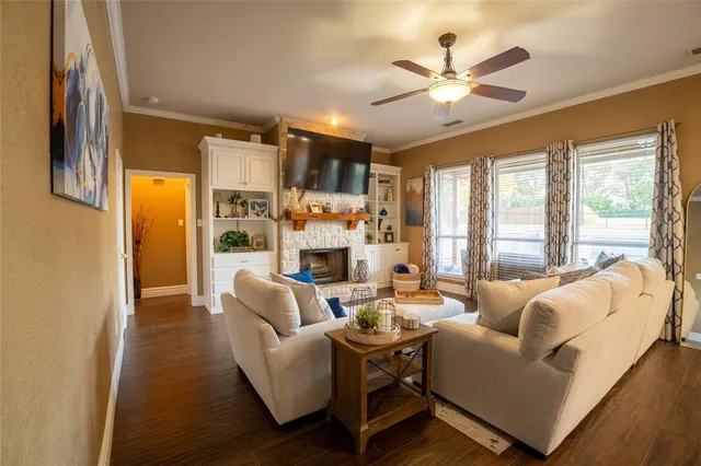 a living room with furniture ceiling fan and a large window
