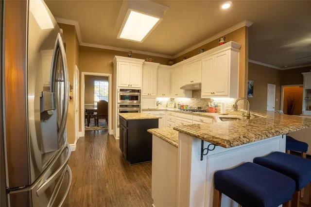a kitchen with stainless steel appliances granite countertop a sink stove and refrigerator