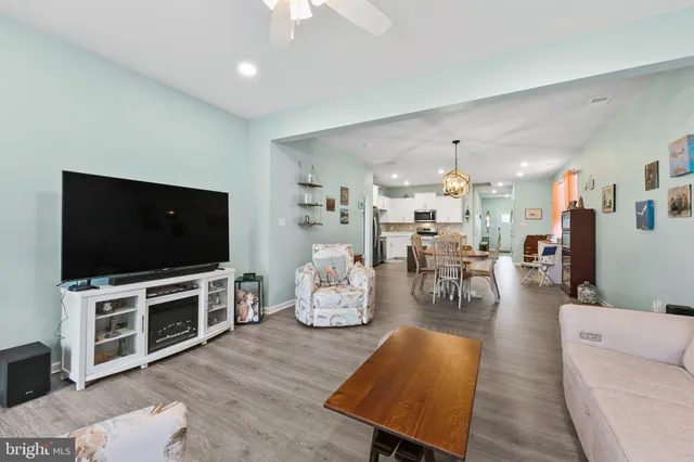 a living room with furniture kitchen and a chandelier