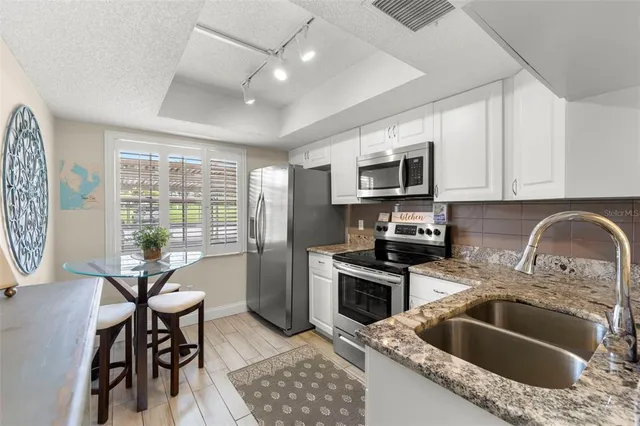a kitchen with granite countertop a sink granite counter tops and a stove top oven