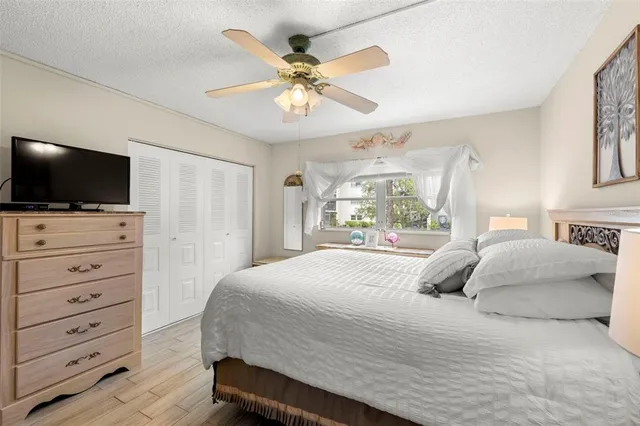 a bedroom with a large bed a flat tv screen and a chandelier