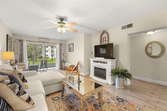 a living room with furniture a flat screen tv and a fireplace