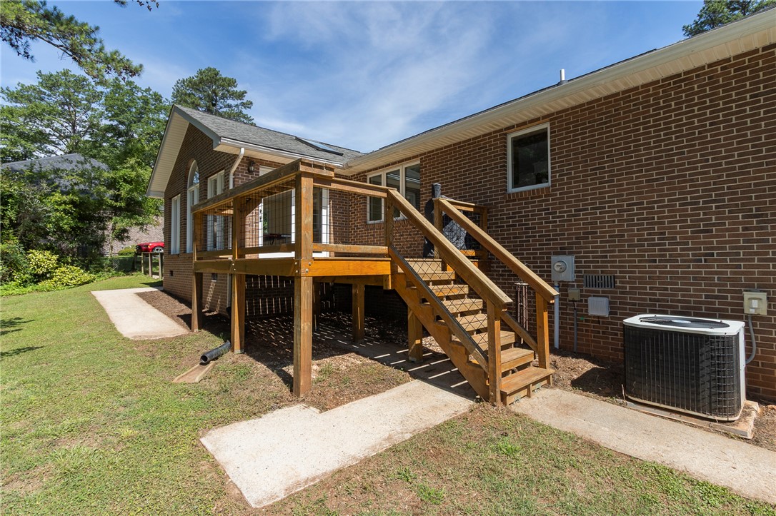 207 Laurel Ridge Road Anderson, SC 29621 - Photo 49 of 50 A grand elevated wooden deck and stairway extend from the home's brick exterior, offering direct access to the generous yard.