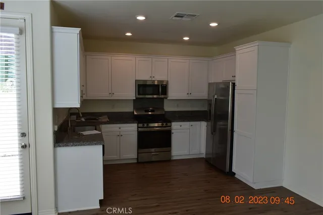 a kitchen with a refrigerator and a stove top oven