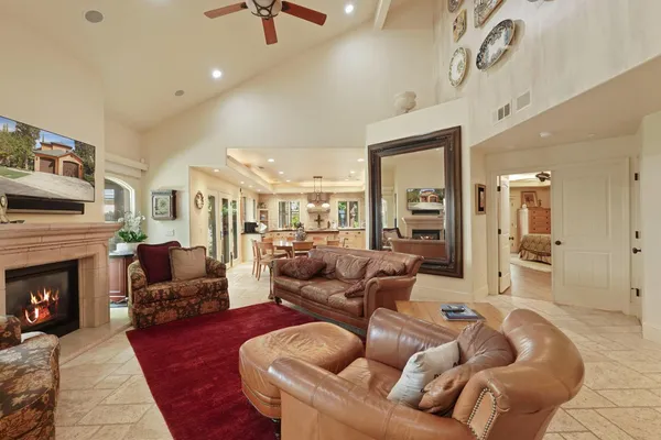 a living room with furniture a fireplace and a large window
