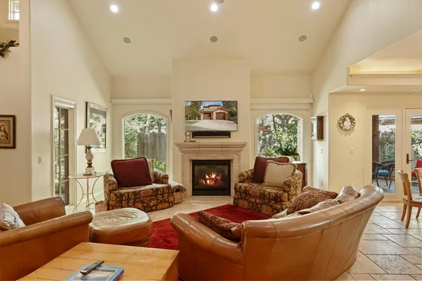 a living room with furniture kitchen view and a wooden floor