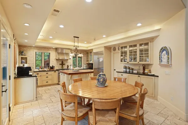 a large kitchen with stainless steel appliances a stove a sink and a refrigerator