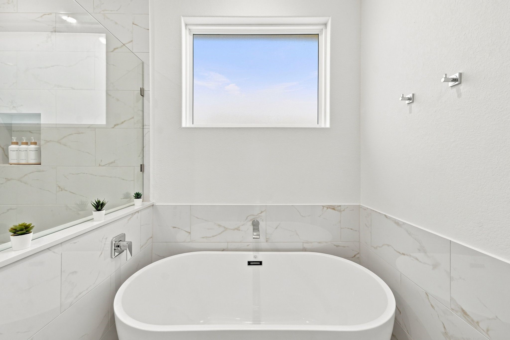 6057 Cebra Street Houston, TX 77091 - Photo 33 of 42 Spa-inspired primary bathroom featuring a relaxing soaking tub, separate shower, and abundant natural light. Photos are from a different property with a similar floor plan. Finishes, features, and orientation may vary.