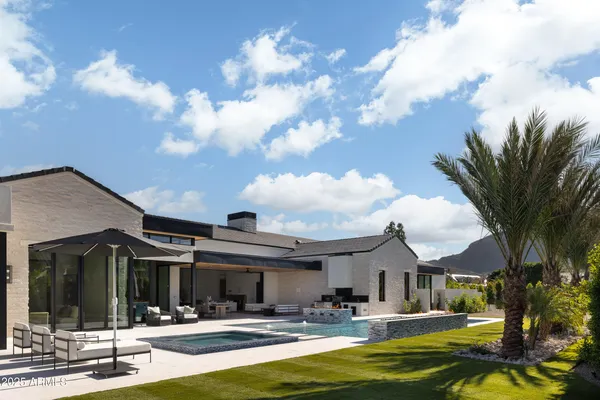 a front view of a house with swimming pool and furniture