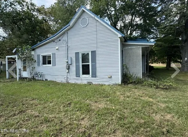 a view of backyard of house with green space